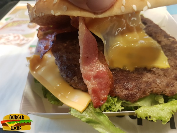 Ein belegter McDonald's Burger mit Fleisch, Käse und Bacon im Brötchen