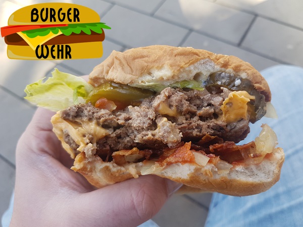 Angebissener Burger mit Käse und Bacon im Querschnitt