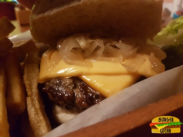 Ansicht eines aufgeklappten Cheeseburgers mit Zwiebeln