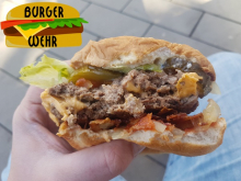 Angebissener Bacon Cheeseburger mit Beilagen